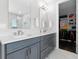 Stylish bathroom with double vanity sinks, modern fixtures, and a view into the organized walk-in closet at 16028 Trivoli Cir, Montverde, FL 34756