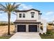 Charming two-story home featuring a stone-accented two car garage, brick-paved driveway, and tile roof at 16028 Trivoli Cir, Montverde, FL 34756