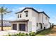 Two-story home boasts a stone-accented garage, black trimmed windows, and neatly landscaped yard at 16028 Trivoli Cir, Montverde, FL 34756