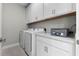 Spacious laundry room with storage cabinets, counter and washer/dryer at 16028 Trivoli Cir, Montverde, FL 34756