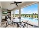 Covered patio features an outdoor kitchen, ceiling fans, and a pool overlooking a green landscape at 16028 Trivoli Cir, Montverde, FL 34756