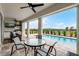 Covered patio features an outdoor kitchen, ceiling fans, and a pool overlooking a green landscape at 16028 Trivoli Cir, Montverde, FL 34756
