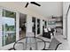 Covered patio with an outdoor kitchen, ceiling fans, outdoor furniture, and sliding glass doors to the home's interior at 16028 Trivoli Cir, Montverde, FL 34756