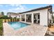 Backyard pool adjacent to a covered patio with seating, an outdoor kitchen, and an adjacent building at 16028 Trivoli Cir, Montverde, FL 34756