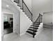 Elegant staircase with dark wood steps and decorative iron railing, leading to the upper level at 16028 Trivoli Cir, Montverde, FL 34756