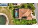 Aerial view of a beautiful home with a screened pool, overlooking a serene lake, and surrounded by a lush yard at 17066 Se 111Th Ter, Summerfield, FL 34491
