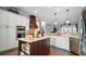 Gourmet kitchen with center island, modern stainless steel appliances, and sleek white cabinetry at 17066 Se 111Th Ter, Summerfield, FL 34491