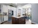 Island kitchen featuring an island with dark wood cabinets, stainless steel appliances and granite countertops at 17066 Se 111Th Ter, Summerfield, FL 34491