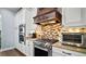 Gourmet kitchen featuring stainless steel range hood, stainless steel appliances, and tile backsplash at 17066 Se 111Th Ter, Summerfield, FL 34491