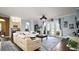 Bright, open living room with white sofas, a ceiling fan, and doors to the backyard at 17066 Se 111Th Ter, Summerfield, FL 34491