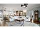 Large living room with an open concept kitchen, white couches, and a statement ceiling fan at 17066 Se 111Th Ter, Summerfield, FL 34491