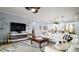 Open-concept living area featuring modern furnishings, decorative shelving, and an electric fireplace at 17066 Se 111Th Ter, Summerfield, FL 34491