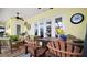 Comfortable screened patio with fan, tv, adjacent indoor bar area and outdoor dining area with chairs at 17066 Se 111Th Ter, Summerfield, FL 34491