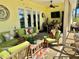 Comfortable screened patio featuring lounge seating, overhead fan and adjacent indoor bar area at 17066 Se 111Th Ter, Summerfield, FL 34491