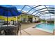 Relax by the poolside featuring an outdoor kitchen, dining area, and a beautiful view from this screened-in oasis at 17066 Se 111Th Ter, Summerfield, FL 34491