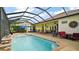 Relaxing screened pool area with ample seating, a waterfall feature, and sunny exposure at 17066 Se 111Th Ter, Summerfield, FL 34491