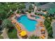 Aerial view of a community pool with lounge chairs and palm trees at 17066 Se 111Th Ter, Summerfield, FL 34491