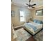 Comfortable bedroom featuring neutral tones, a ceiling fan, and a large window that provides plenty of natural light at 17066 Se 111Th Ter, Summerfield, FL 34491