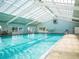 Bright indoor pool with ample natural light, creating a serene environment for swimming and relaxation year-round at 17066 Se 111Th Ter, Summerfield, FL 34491