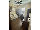Home office with a ceiling fan, a comfortable sitting area, desk, and shelves for books or office supplies at 17066 Se 111Th Ter, Summerfield, FL 34491