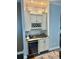 This wet bar features white cabinetry, granite countertops, a wine refrigerator, and built-in storage at 17066 Se 111Th Ter, Summerfield, FL 34491