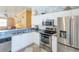 Modern kitchen featuring stainless steel appliances, sleek white cabinetry, and ample counter space for cooking at 1723 Morelos Rd, The Villages, FL 32159
