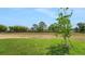 Large grassy backyard featuring a new tree, privacy fence, and lush green space at 179 Bottle Brush Dr, Haines City, FL 33844