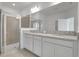 Bathroom featuring a double vanity, granite countertops, and a glass-enclosed walk-in shower at 179 Bottle Brush Dr, Haines City, FL 33844