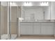 Bright bathroom featuring a double vanity with granite countertop and a glass enclosed walk-in shower at 179 Bottle Brush Dr, Haines City, FL 33844