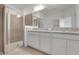 Bright bathroom featuring a double vanity with granite countertop and a glass enclosed walk-in shower at 179 Bottle Brush Dr, Haines City, FL 33844