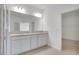 Bright bathroom with a double vanity, granite countertop, large mirror, and access to the walk-in closet at 179 Bottle Brush Dr, Haines City, FL 33844