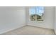 Bright, carpeted bedroom with a large window overlooking the neighborhood at 179 Bottle Brush Dr, Haines City, FL 33844
