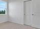 Bedroom with white walls, carpet, and a double door closet next to a window at 179 Bottle Brush Dr, Haines City, FL 33844