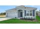 Charming single-Gathering home with a well-manicured lawn, gray exterior, and an attached two-car garage at 179 Bottle Brush Dr, Haines City, FL 33844