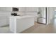 Modern kitchen featuring stainless steel appliances, a large island, and sleek white countertops at 179 Bottle Brush Dr, Haines City, FL 33844