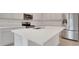 Close-up on an island kitchen with stainless appliances, white countertops, and ample storage at 179 Bottle Brush Dr, Haines City, FL 33844