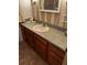 Bathroom featuring wood vanity cabinets, and a countertop with a sink and framed mirror at 201 Jacaranda Dr, Leesburg, FL 34748
