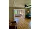Living room with hardwood floors, a ceiling fan, and an adjacent sunroom with plenty of light at 201 Jacaranda Dr, Leesburg, FL 34748
