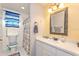 Bathroom features a toilet, window with blue-striped curtain, and vanity with ample counter space at 202 N Palm Ave, Howey In The Hills, FL 34737