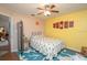 Bright bedroom featuring a ceiling fan, vibrant area rug, and wall art at 202 N Palm Ave, Howey In The Hills, FL 34737