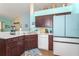Open kitchen featuring stainless steel appliances, white counter tops, and tiled floors at 202 N Palm Ave, Howey In The Hills, FL 34737