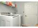 Laundry room with modern white washer and dryer units, wire shelving, and a white door at 202 N Palm Ave, Howey In The Hills, FL 34737