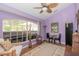 Bright living room featuring a ceiling fan and a large window letting in natural light at 202 N Palm Ave, Howey In The Hills, FL 34737