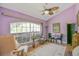 Cozy living room featuring vaulted ceilings, large windows, and neutral decor at 202 N Palm Ave, Howey In The Hills, FL 34737