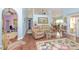 Open living room featuring vaulted ceilings, laminate flooring, and sun-filled windows at 202 N Palm Ave, Howey In The Hills, FL 34737