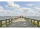 Long wooden pier extends into the water, featuring a covered gazebo at the end at 202 N Palm Ave, Howey In The Hills, FL 34737