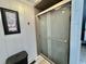 Shower stall with sliding glass doors, tile surround, and white paneled walls at 207 Hawthorne Blvd, Leesburg, FL 34748
