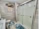 Bathroom featuring a glass-enclosed shower, wood plank walls, and decorative accents at 207 Hawthorne Blvd, Leesburg, FL 34748