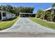 Long driveway leading to a home with a screened-in porch and well-maintained landscaping at 207 Hawthorne Blvd, Leesburg, FL 34748