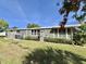 View of the home exterior showing the lawn, plants, and HVAC units at 207 Hawthorne Blvd, Leesburg, FL 34748